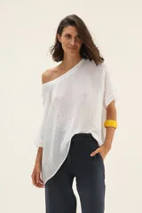 Blusa blanca de lino con mangas murciélago y escote redondo.
