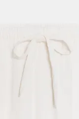 Pantalón negro de tiro medio con bolsillos delanteros y traseros. Cintura elástica ajustable con cordones.