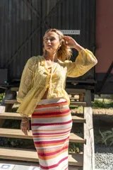 Pollera midi tejida a rayas horizontales en tonos beige, naranja, fucsia y gris.