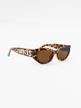 Lentes de sol con montura de acetato con estampado animal print y lentes marrones. El logo de Palm Angels está grabado en las patillas.