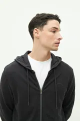 Campera de felpa negra con capucha ajustable y cierre frontal.
