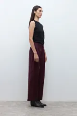 Pantalón de mujer color beige, tiro alto, con pliegues (pinzas) frontales y corte ancho y recto en las piernas.