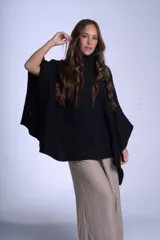 Poncho polerón negro tejido con cuello alto y mangas 3/4.