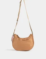 Bandolera hobo negra de tela deportiva con correa regulable, cierre superior, bolsillo frontal y charm lateral decorativo.
