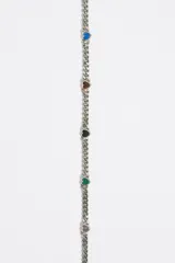 Collar dorado con cadena de eslabones y pequeños dijes de corazones negros.