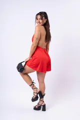 Mono corto de color rojo con escote halter y espalda descubierta.