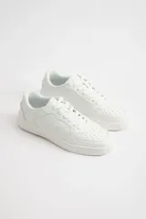 Zapatillas urbanas blancas de cuero sintético con cordones y suela plana.