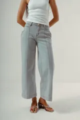 Pantalón de denim color marrón oscuro, tiro medio, con silueta wide leg y costuras verticales marcadas en el frente de ambas piernas.
