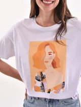 Remera color amarillo claro con estampado de limones, hojas y flores en tonos verdes y grises.