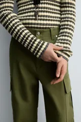 Pantalón cargo verde oliva de corte relaxed fit, confeccionado en tejido de algodón compacto con estructura twill. Cuenta con bolsillos frontales, traseros de vivo y bolsillos plastrón con solapa en las perneras.