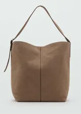 Bolso grande tipo shopper color marrón topo, de piel serraje, con asa corta y asa larga regulable con hebilla. Tiene cierre de cremallera y cierre de imán interior, bolsillo interior y forro de algodón.