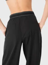 Pantalón negro de tela suave y ligera, con cintura elástica estilo bóxer, pinzas delanteras y bolsillos laterales.