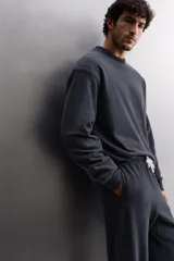 Sudadera de entrenamiento color gris claro, de corte relaxed fit, confeccionada en tejido de algodón con interior de rizo. Tiene cuello redondo, manga larga y acabados en rib.