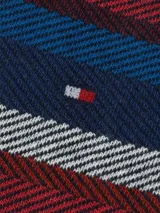 Pack de dos pares de medias Tommy Hilfiger para hombre. Un par es liso color azul marino con el logo de la marca en el tobillo, y el otro par es azul marino con rayas horizontales rojas, blancas y azules.