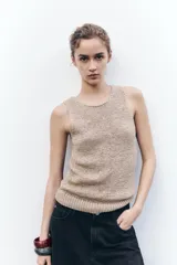 Top color beige de punto rústico con cuello redondo y sisa.