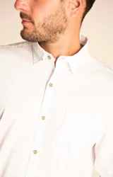 Camisa amarilla de algodón orgánico, manga larga con botones de madera, cuello italiano, calce regular, bolsillo de pecho con logo bordado.
