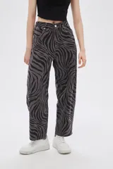 Pantalón de jean de tiro alto con estampado animal print de cebra en tonos borgoña y negro.