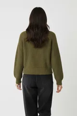 Sweater de algodón color crema, de punto acanalado, con cuello polera y diseño holgado de manga larga.