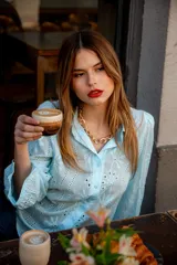 Camisa color beige con bordado inglés, de corte recto, manga larga abullonada con puño y cuello camisero.