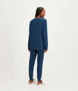 Conjunto de pijama femenino de poliéster y elastano, compuesto por una remera de manga larga con cuello en V y un pantalón largo con puños ajustados. Estampado animal print de jaguar.