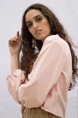 Buzo color rosa pálido de algodón y elastano, de corte holgado y mangas largas abullonadas con puños elásticos.