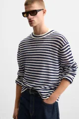 Jersey de punto con rayas horizontales en azul marino y blanco, cuello redondo y manga larga.