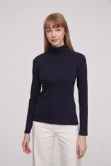 Polera de manga larga color blanco, ajustada al cuerpo y cuello alto.