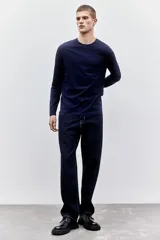 Remera azul marino de punto liviano de mezcla de algodón, de manga larga con cuello redondo ribeteado y bajo recto. Corte ajustado que realza el contorno del cuerpo creando una silueta entallada.