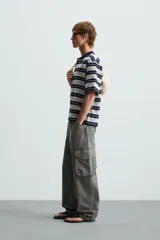 Polo de hombre corte holgado con cuello solapa y cierre de botones. Diseño a rayas horizontales grises y azul marino.