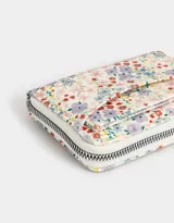 Billetera pequeña de cuerina estampada con diseño floral multicolor, cierre de cremallera y bolsillo frontal abierto.