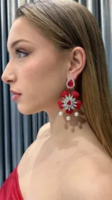 Aros colgantes con forma de flor roja con centro de strass y perlas colgantes.
