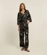 Pantalón wide leg negro con estampado de hojas en color crema, cintura elastizada y bordado de follaje.