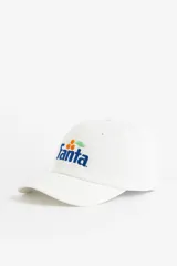Gorra de béisbol blanca con logo bordado de Fanta en el frente.