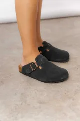 Zuecos de cuero color beige, con diseño clásico y hebilla regulable. Cuentan con plantilla anatómica y suela de corcho.