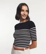 Blusa de punto con textura acanalada, escote barco y mangas 3/4. Diseño a rayas horizontales blancas y negras.