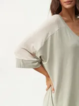 Remera color beige con escote en V y mangas cortas ranglán en color crema.