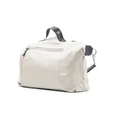 Bolso tote de cuero color taupe, con acceso superior con cierre y correa de hombro negra con letras blancas.