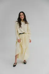 Falda midi color crema, amplia y de corte evasé, confeccionada en viscosa y lino, con bolsillos laterales y cintura alta.