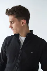 Campera marrón de algodón con cierre frontal, cuello alto, bolsillos laterales, puños y logo bordado en el pecho.