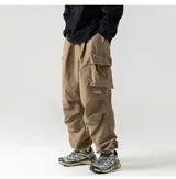Pantalón cargo de trekking color caqui, con múltiples bolsillos con tapa y cordones ajustables en cintura y tobillos. Presenta un pequeño logo bordado en la pierna derecha.