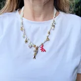 Collar corto hecho en pañuelo marrón con mix de dijes dorados, rojos y blancos.