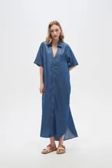 Vestido largo camisero de lyocell azul denim, corte holgado, con cuello camisero, mangas cortas con dobladillo y cierre frontal con botones.