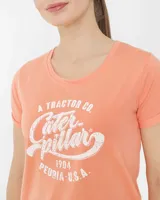 Remera color salmón de corte crop, con cuello redondo y mangas cortas con dobladillo. Estampado frontal con texto en blanco.