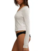 Top de manga larga color crema, de punto ligero tipo pointelle con escote en V y detalles de encaje en el cuello y puños.