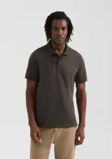 Polo verde oscuro de manga corta, confeccionada en algodón pima, con cuello clásico y tapeta de dos botones.