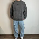 Pantalón jean cargo negro con corte holgado y múltiples bolsillos.