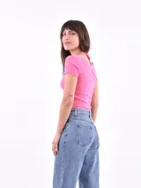 Top corto fucsia de tejido de punto acanalado, con escote en V y lazo ajustable en el centro.