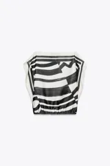 Top de Zara Woman Collection, con estampado abstracto en blanco y negro, cuello barco, mangas caídas y bajo ajustable con lazadas.