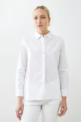 Camisa blanca de manga larga con cuello clásico y cierre frontal con botones.
