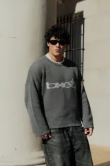 Sweater gris con diseño gráfico en el frente, corte holgado y mangas largas.